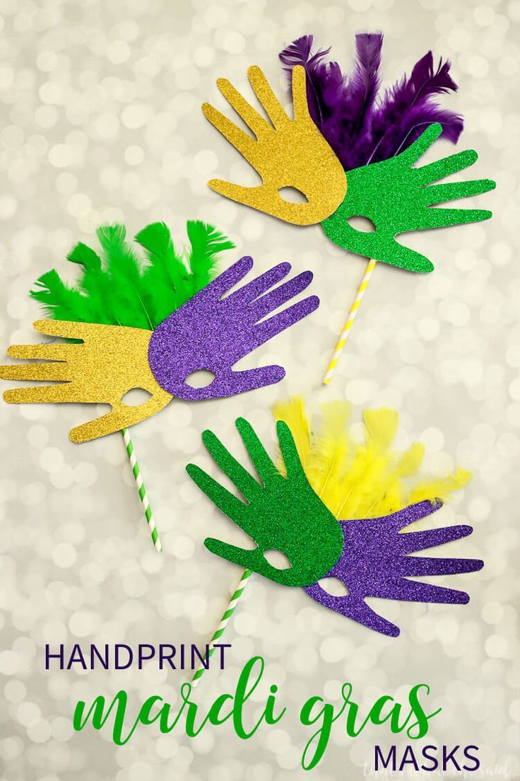 two handprint mardi gras masks with purple, yellow and green feathers