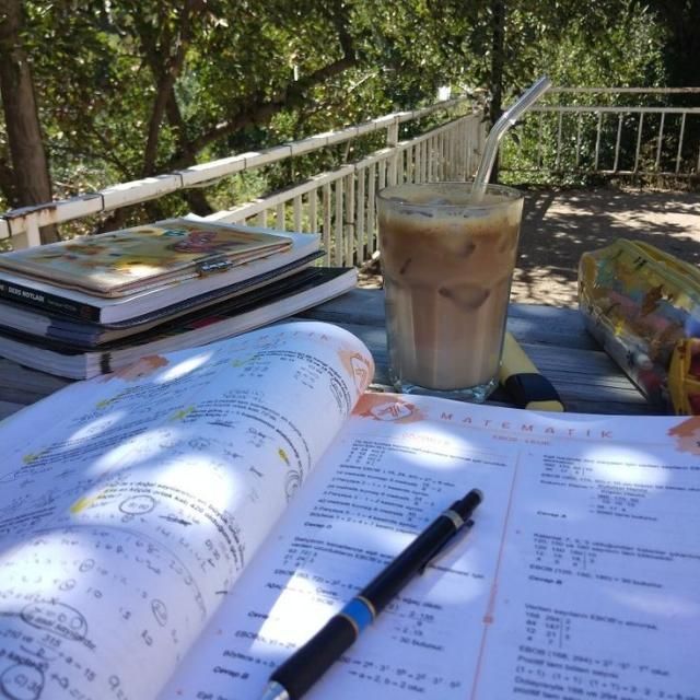 an open book sitting on top of a table next to a drink