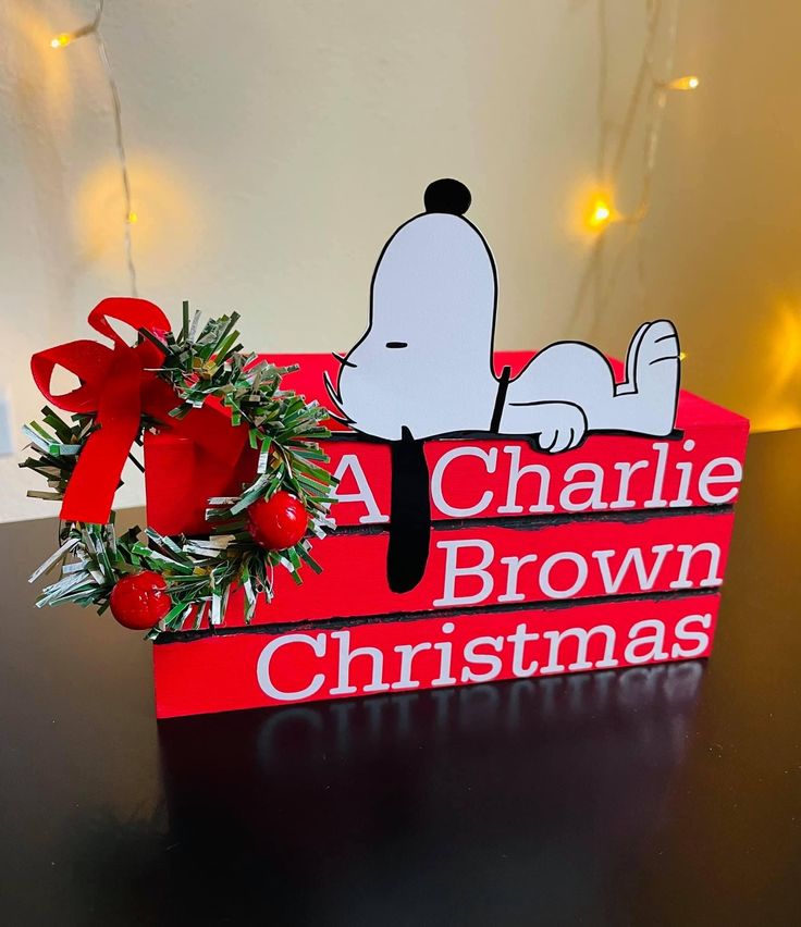 a charlie brown christmas sign sitting on top of a table next to a red bow