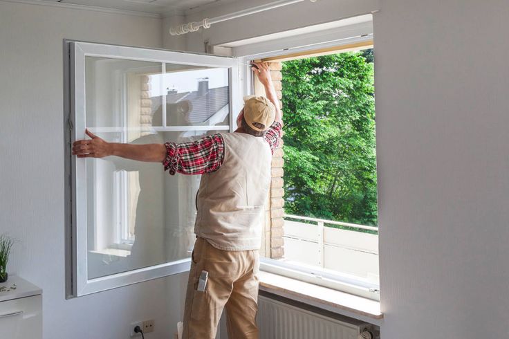 a man that is standing up on a window sill with his hands in the air