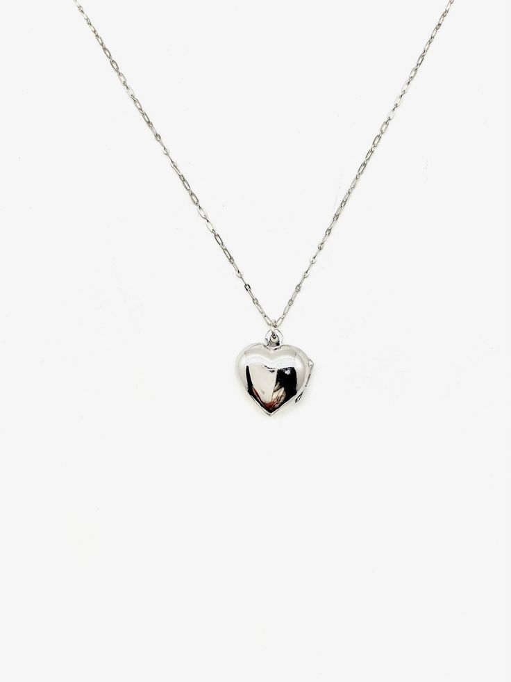 Embrace the nostalgia of the past and celebrate your love story with this heart-shaped sterling silver locket. A symbol of enduring love, this vintage gem is not just jewelry; it's a classic piece that spans decades. Discover timeless love with our Silver Jane Locket, a unique vintage treasure straight from the 1960s. The secure click-shut design ensures your cherished memories stay safely tucked away. The 17" sterling silver chain elegantly complements the locket, adding a touch of sophisticati Classic Heart-shaped Sterling Silver Necklace, Silver Heart Necklace For Wedding, Fine Jewelry, Classic White Gold Jewelry With Heart Charm, Classic Jewelry With Heart Charm And Heart Cut, Classic Open Heart Jewelry For Valentine's Day, Elegant Nickel Free Double Heart Jewelry, Elegant Nickel-free Double Heart Jewelry, Classic Heart Cut Jewelry With Heart Charm, Valentine's Day Fine Jewelry Locket