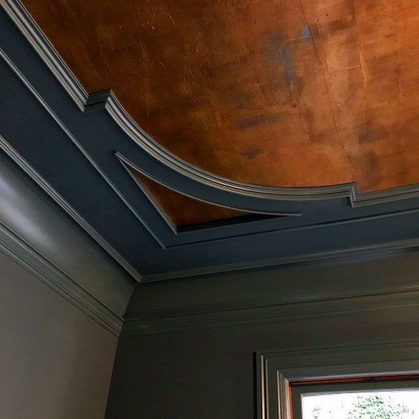 the corner of a room with a window and wood paneling on the ceiling above it