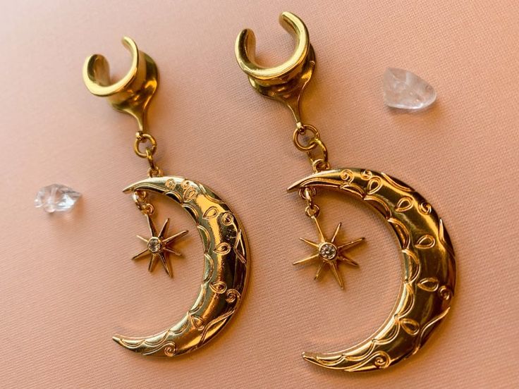 2g (6mm) - 1 3/16 (30mm) Gold Tone Crescent Moon & Star Saddles Drop Dangle Earrings Gauges/Earplugs Plugs.PLEASE read section regarding sizing before purchasing as due to sensitive nature of my products (body jewelry) as I cannot accept returns or exchanges. The details:-316L stainless steel saddle. -Features gold tone alloy crescent moon and 18k gold plated star with zircon center. -All earrings are assembled by hand and sold in pairs.-Available from 2g (6mm) to 30mm.-Each earring (not includi Celestial Star Jewelry For Festival, Internally Threaded Crescent Piercings For Gift, Internally Threaded Crescent Piercings As A Gift, Mystical Internally Threaded Jewelry As Gift, Mystical Internally Threaded Jewelry For Gift, Mystical Internally Threaded Jewelry For Gifts, Moon Shaped Internally Threaded Jewelry As Gift, Bohemian Internally Threaded Body Jewelry As Gift, Adjustable Celestial Style Body Jewelry For Gifts