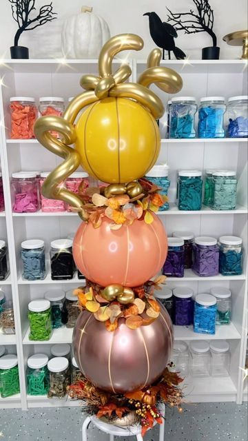 some balloons are stacked on top of each other in front of shelves with yarn and thread