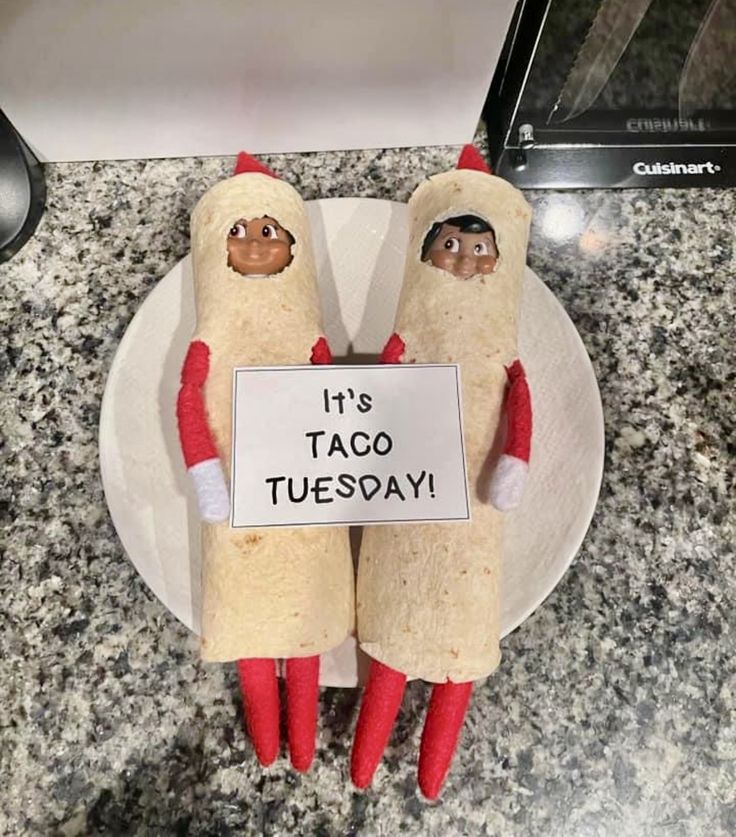 there are two chili dogs on a plate with a sign that says it's taco tuesday