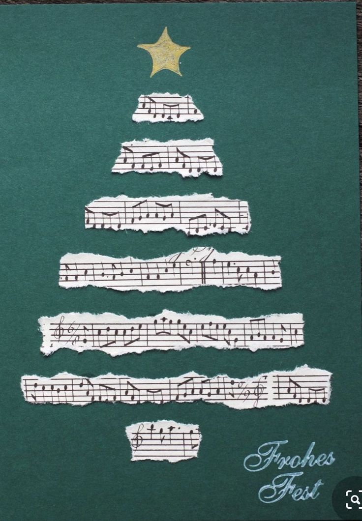 a christmas tree made out of sheet music on a piece of green paper with gold star