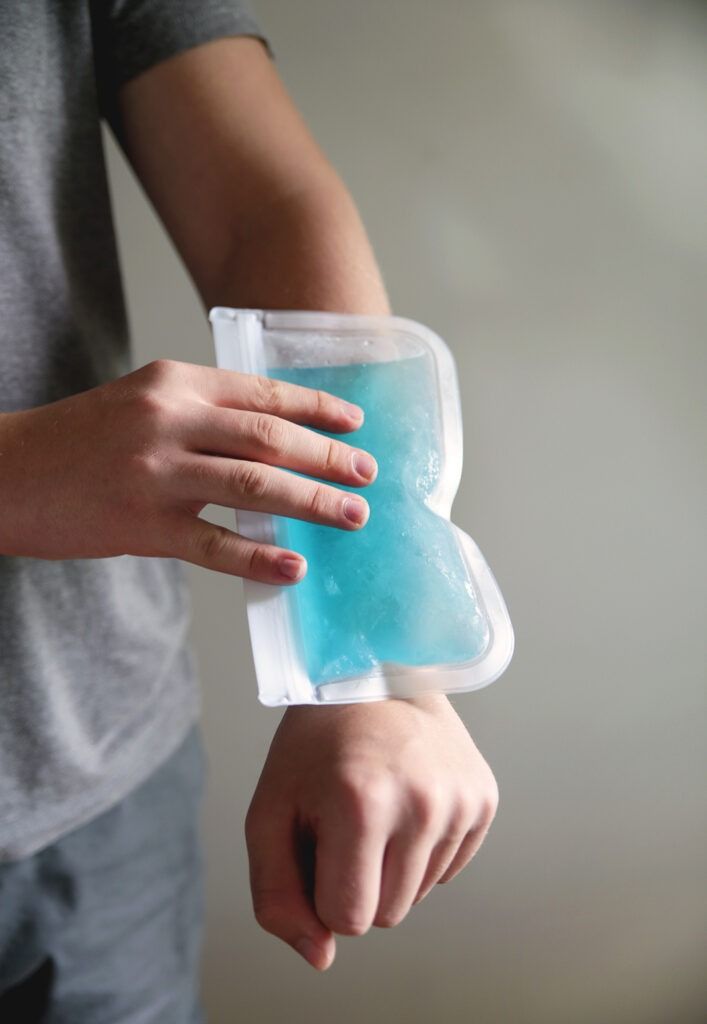 a person holding a container with blue substance in it's palm and one hand