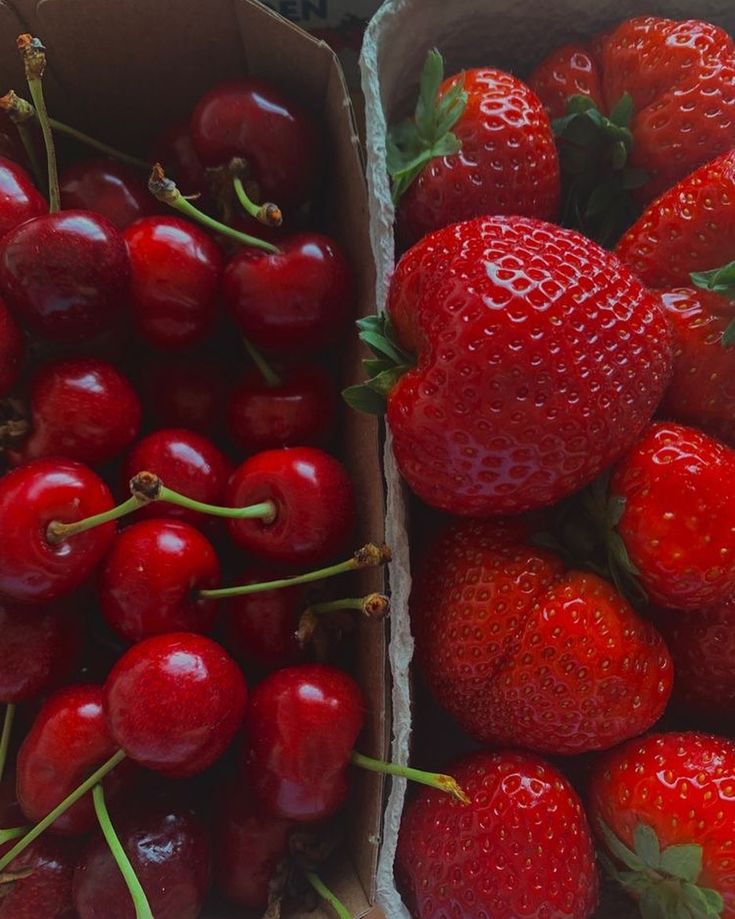 two boxes filled with lots of ripe strawberries