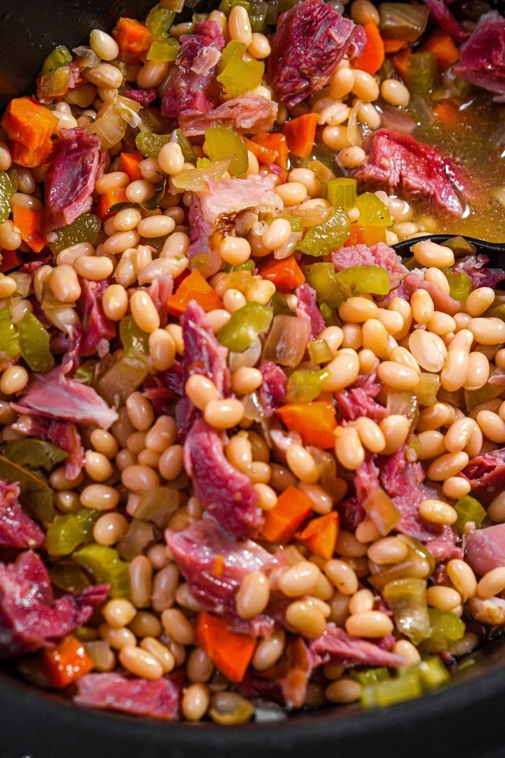 a pot filled with beans, ham and vegetables