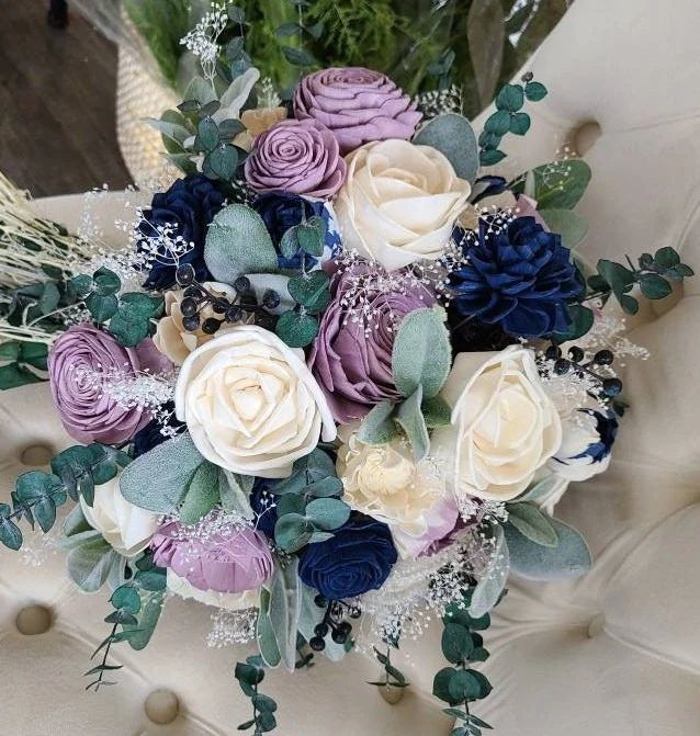 a bridal bouquet sitting on top of a white chair