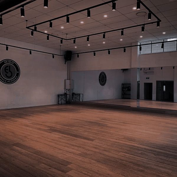 an empty room with hard wood flooring and lights hanging from the ceiling above it