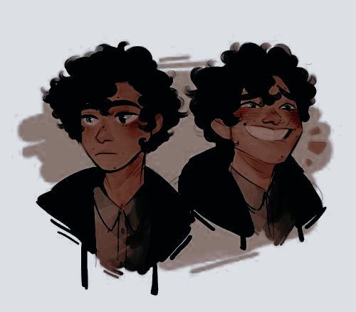 two young men, one with curly hair and the other without his eyes are smiling