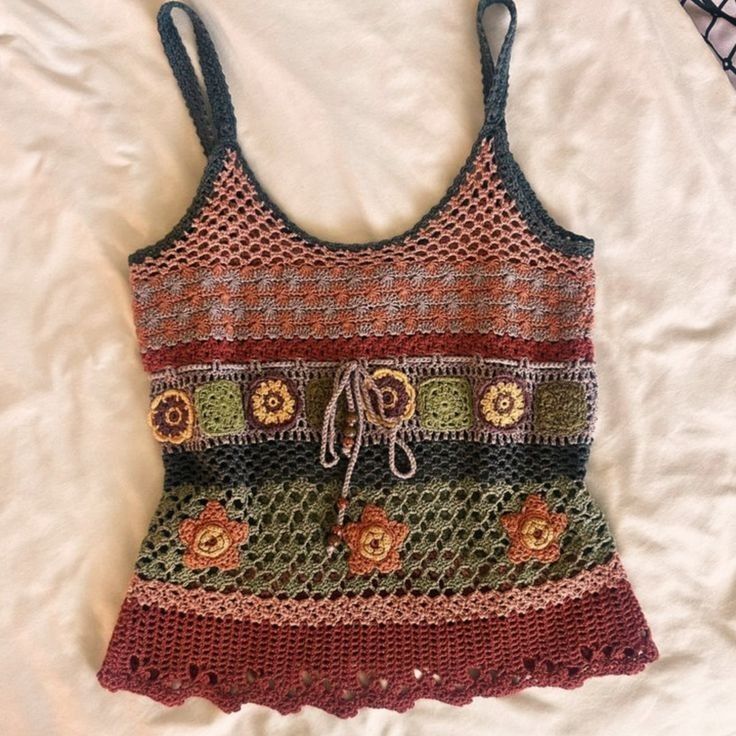 a crocheted tank top is laying on a bed