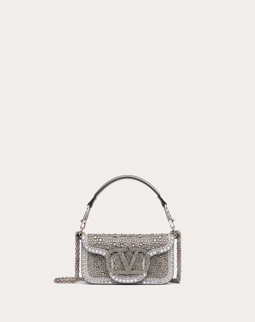 Valentino Garavani Locò small shoulder bag with rhinestone appliqué and Swarovski® covered VLogo Signature element. Equipped with both a detachable sliding chain strap and a detachable handle, this accessory can be worn as a crossbody/shoulder bag or carried as a handbag. - Palladium-finish hardware - Magnetic closure - Removable leather handle - Shoulder strap with removable sliding chain - Nappa leather lining. Interior: one slip pocket Shoulder strap drop length: min. 33 cm to max. 55 cm / mi Studded Sneakers, Micro Bag, Mini Bucket Bags, Mini Crossbody Bag, Purses Designer, Small Shoulder Bag, Nappa Leather, Clutch Wallet, Lambskin Leather