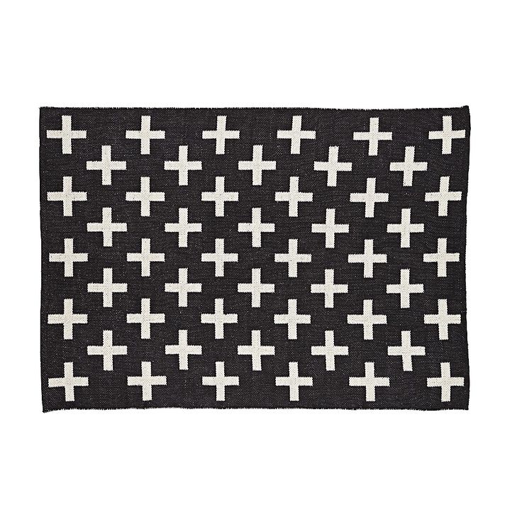 a black and white rug with crosses on the front, in various sizes and colors