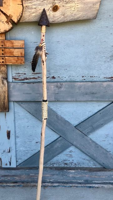 an old wooden pole with a feather on it