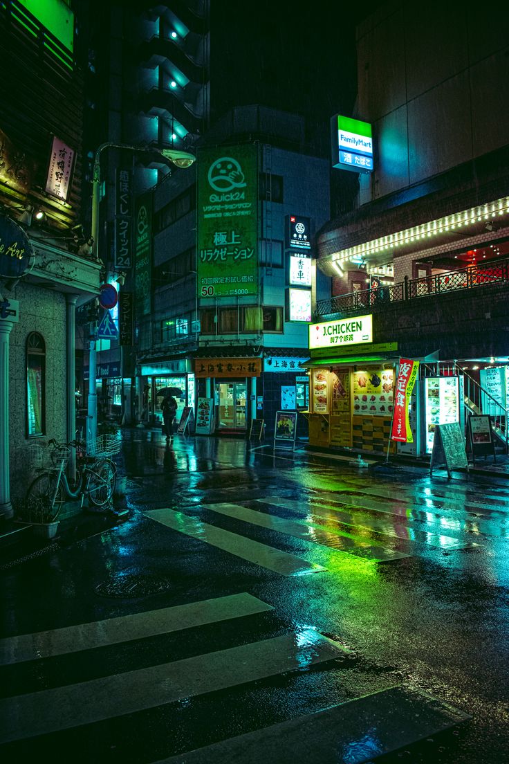 a city street at night with people walking on the sidewalk and buildings lit up in neon lights