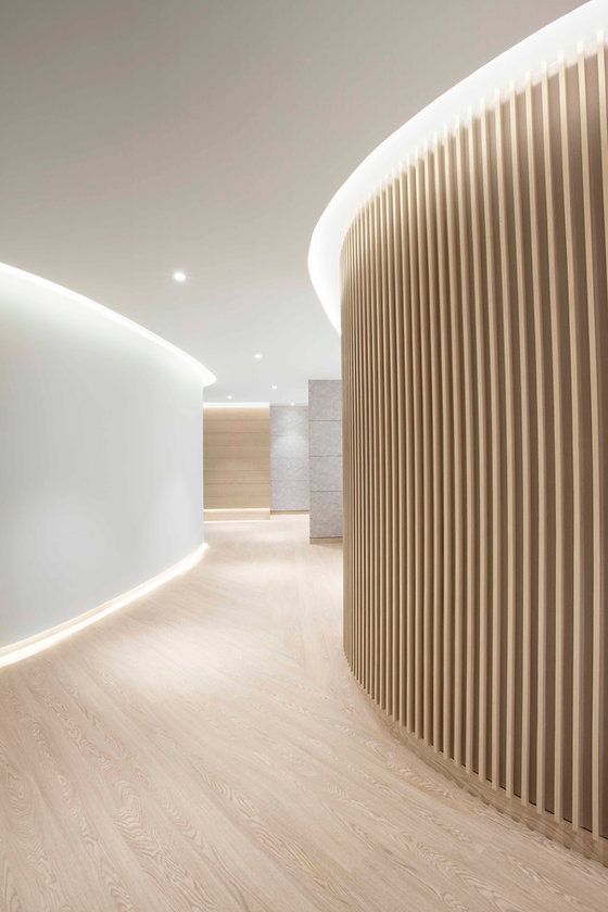 an empty room with wooden slats on the walls and wood flooring in front of it