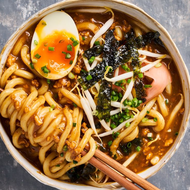 an overhead view of a bowl of ramen with noodles, egg and greens on top