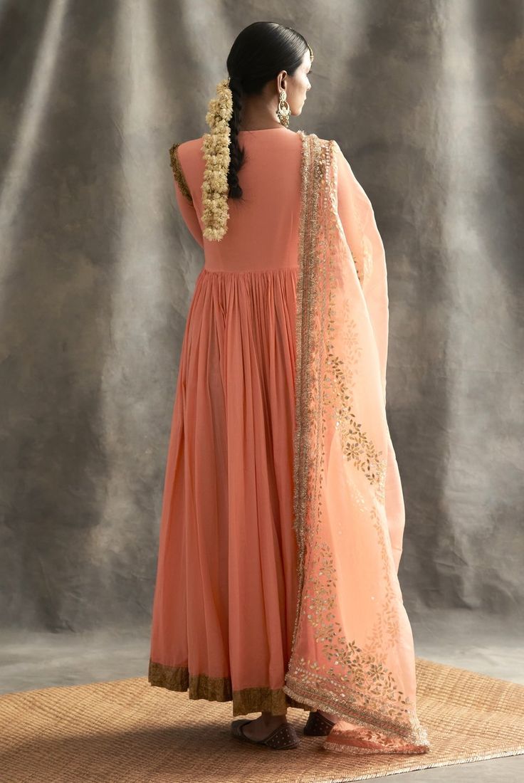 This set features a kurti with one of the kind embossed khadi highlighted with dabka and zardozi,the 2 paneled sharara also has the intricate khadi blocking, while the dupatta is made of organza wi... Peach Kurta With Zari Work For Wedding, Peach Traditional Anarkali Set For Diwali, Traditional Peach Anarkali Set For Diwali, Peach Anarkali Set For Reception With Traditional Drape, Traditional Peach Anarkali Set With Resham Embroidery, Traditional Designer Wear Peach Sharara, Peach Anarkali In Georgette, Peach Traditional Wear With Dupatta For Reception, Designer Peach Dupatta For Navratri