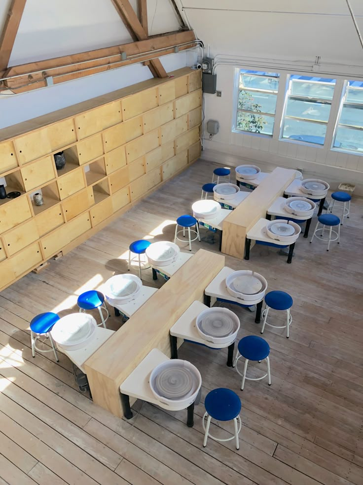 an overhead view of tables and chairs in a room with wood flooring, wooden walls and windows