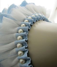 a white and blue dress with pearls on it