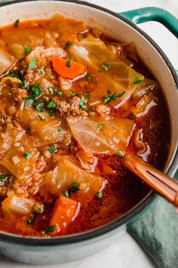 a pot filled with soup and vegetables on top of a table