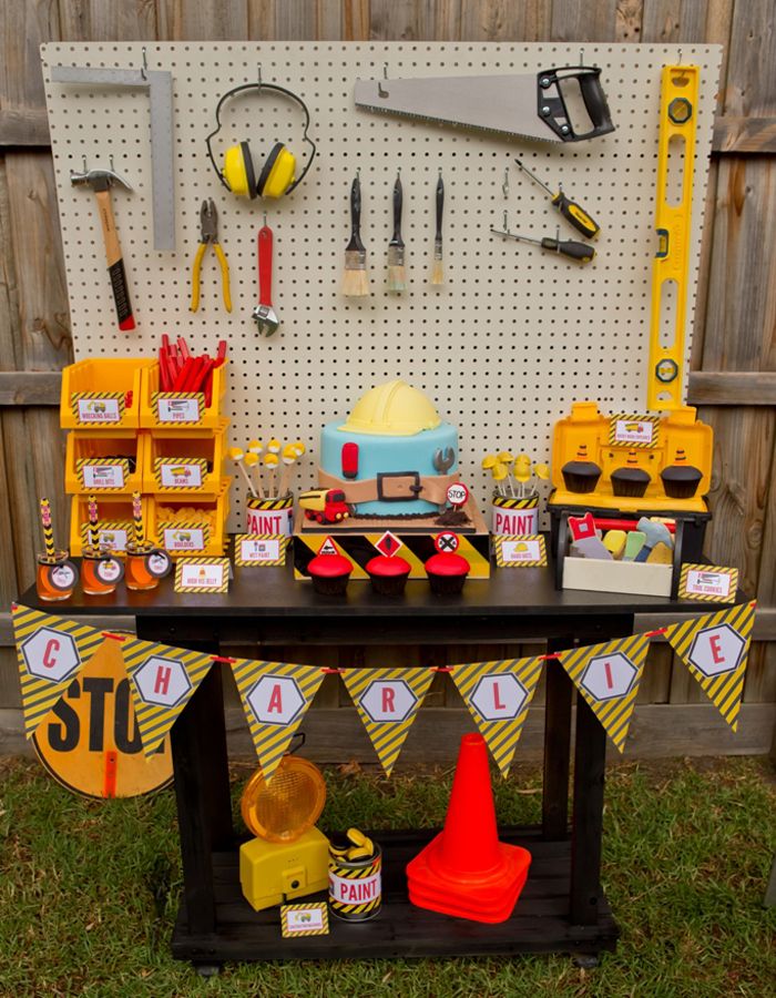 a table topped with lots of tools and construction themed signs on it's sides