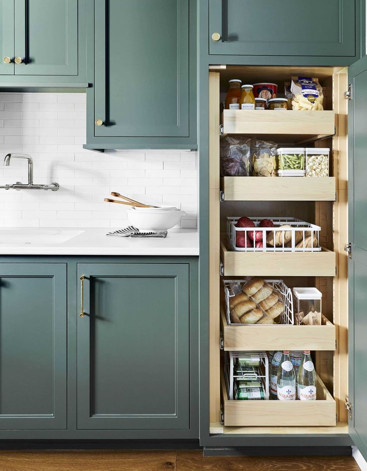 an open cabinet in a kitchen filled with lots of food and storage space next to a sink