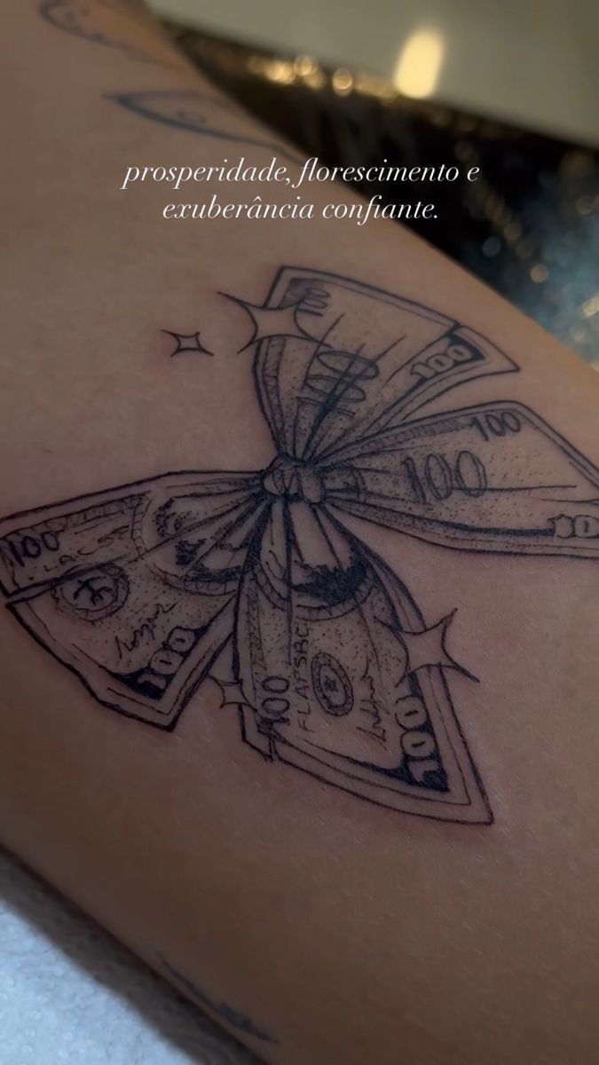 a woman's thigh with money tattoo on it