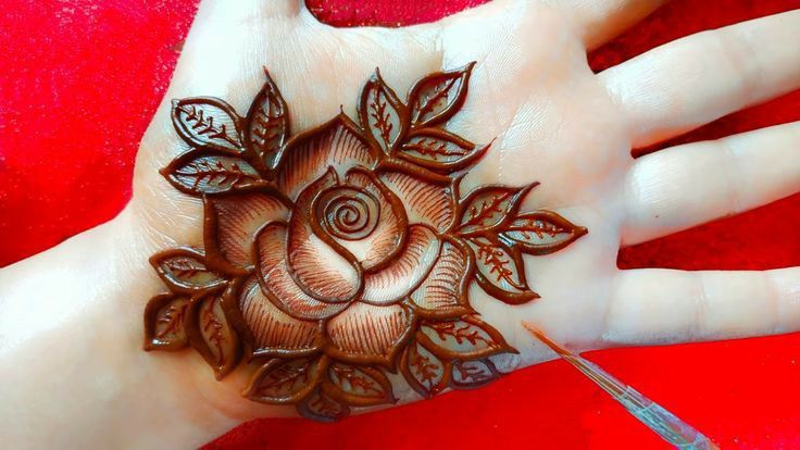 a woman's hand is decorated with hendi and flower designs on the palm