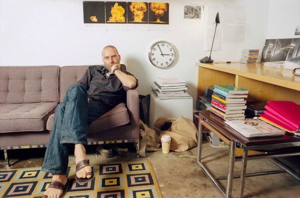 a man sitting in a chair with his feet up on the floor next to a table