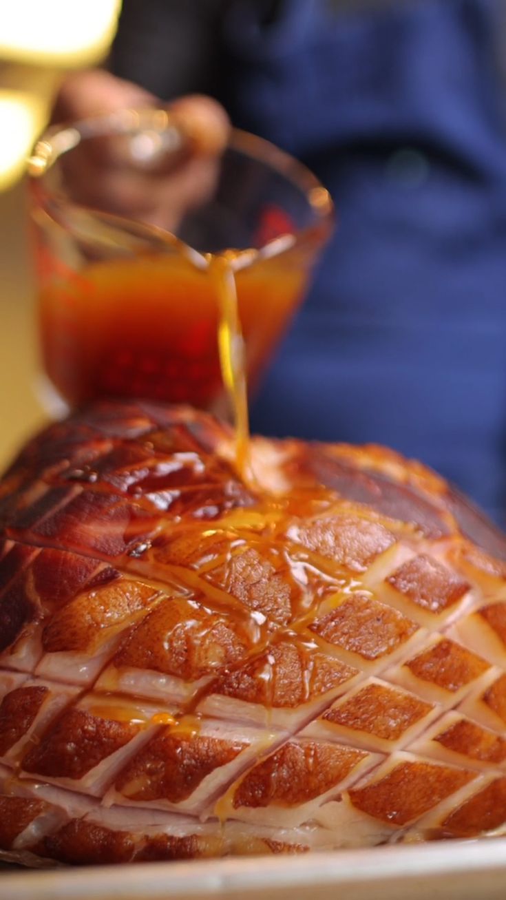 someone pouring sauce on top of a large piece of bread that is sitting on a plate