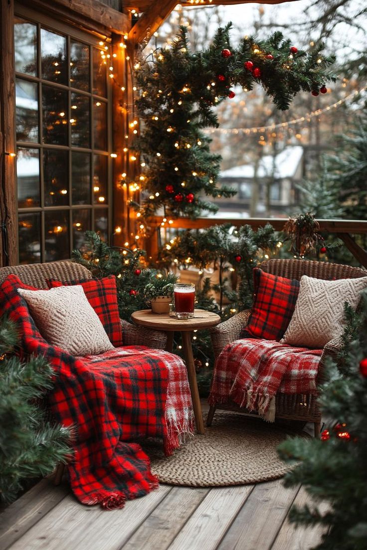 a porch decorated for christmas with red and black plaid furniture, evergreen garlands and lights