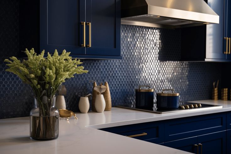 a kitchen with dark blue cabinets and white counter tops, gold accents on the backsplash