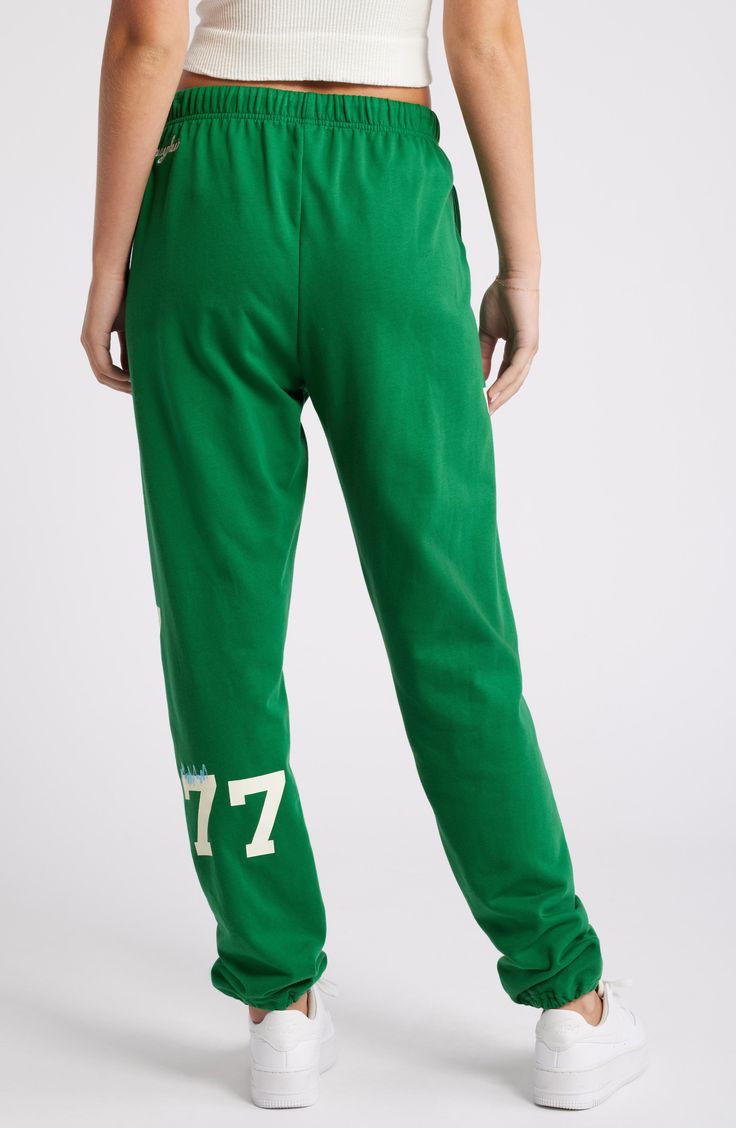 Number graphics lend varsity style to lounge-ready sweatpants cut from a breathable cotton blend. 32" inseam; 12" leg opening; 13" front rise; 16" back rise (size Large/X-Large) Elastic waist Side-seam pockets Elastic cuffs 84% cotton, 16% polyester Machine wash, line dry Imported Green Cotton Activewear For Exercise, Varsity Style Relaxed Fit Sweats For Loungewear, Sporty Graphic Print Bottoms Relaxed Fit, Casual Green Bottoms For Sports Season, Sporty Bottoms With Graphic Print And Relaxed Fit, Sporty Relaxed Fit Pants With Graphic Print, Collegiate Style Cotton Sweats For Loungewear, Collegiate Relaxed Fit Sweats For Loungewear, Athleisure Cotton Bottoms With Graphic Print