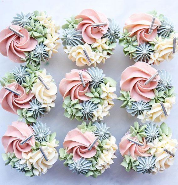 cupcakes decorated with pink and white frosting are arranged in a circle on a table