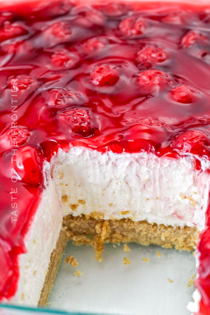 a close up of a cake with cherries on top and white frosting in the middle