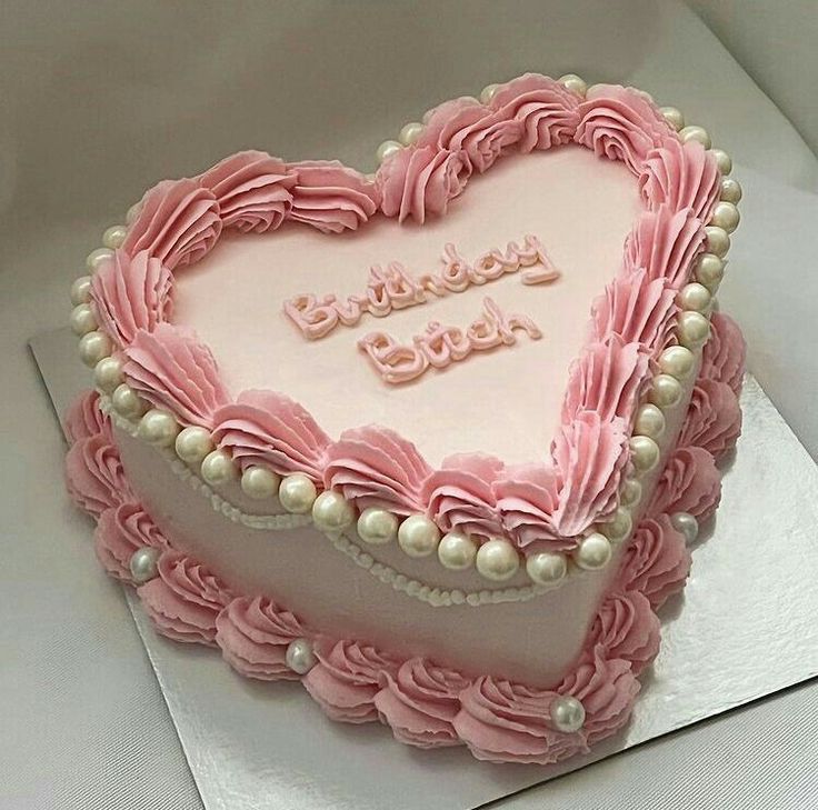 a heart shaped cake with pink icing and pearls