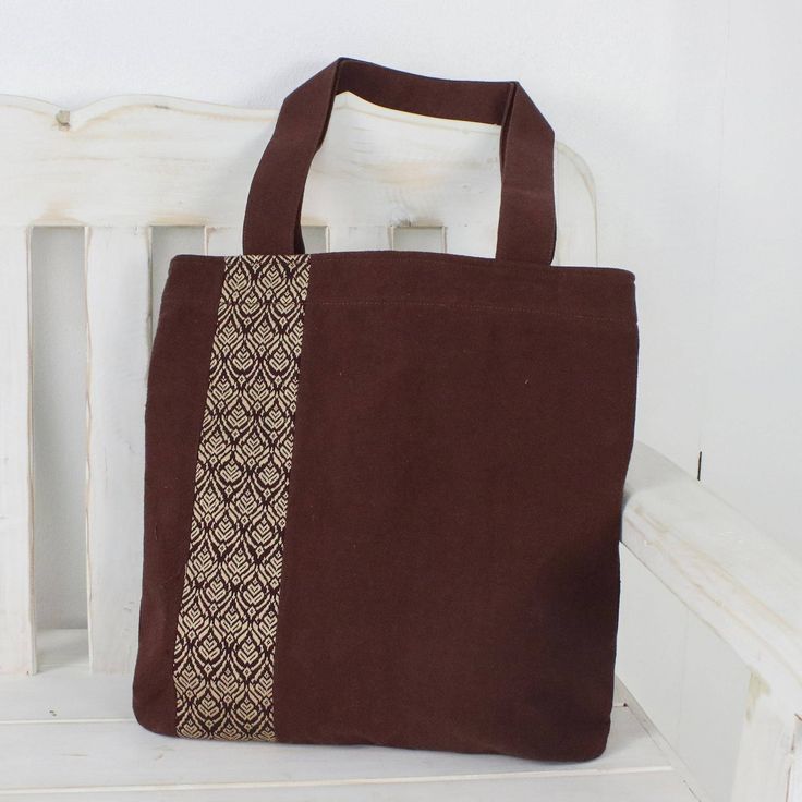 Keawpankanlaya of Thailand creates this pretty tote bag from 100% cotton in a rich mahogany shade. The front of the tote is embellished with traditional Thai yok dok embroidery in cream. The bag closes with a zipper to keep your belongings secure and an open interior pocket keeps small items close at hand. Square Brown Canvas Bag, Brown Square Canvas Bag, Everyday Embroidered Brown Bags, Brown Embroidered Everyday Bags, Everyday Brown Embroidered Bags, Brown Everyday Embroidered Bags, Traditional Cotton Bag For Everyday Use, Handmade Brown Rectangular Canvas Bag, Brown Double Handle Gift Bag