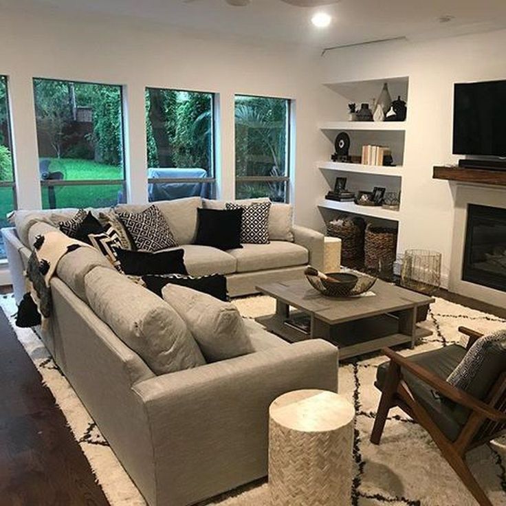 a living room filled with furniture and a flat screen tv mounted on the wall above a fireplace