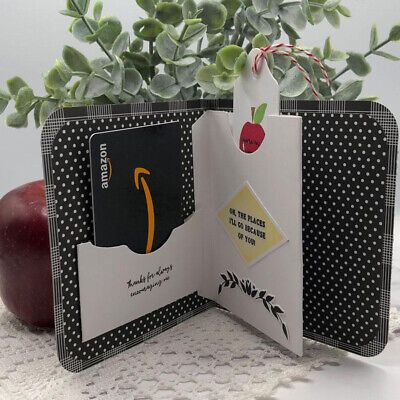 an open wallet sitting on top of a table next to a potted plant and apple