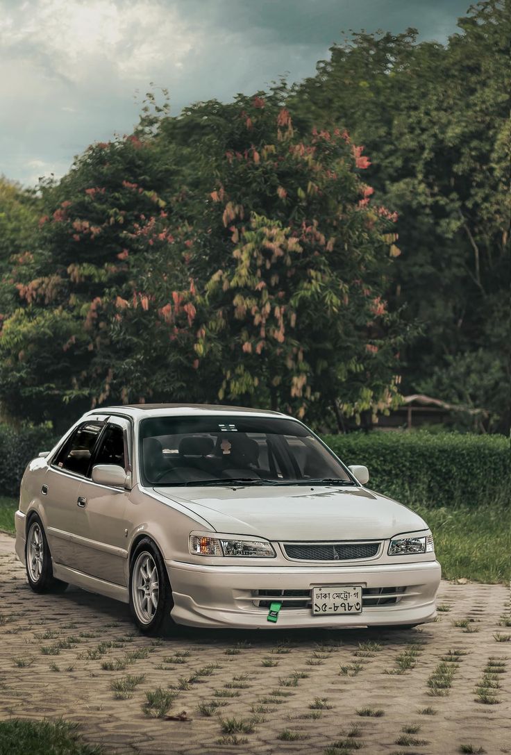 a white car parked on top of a dirt road