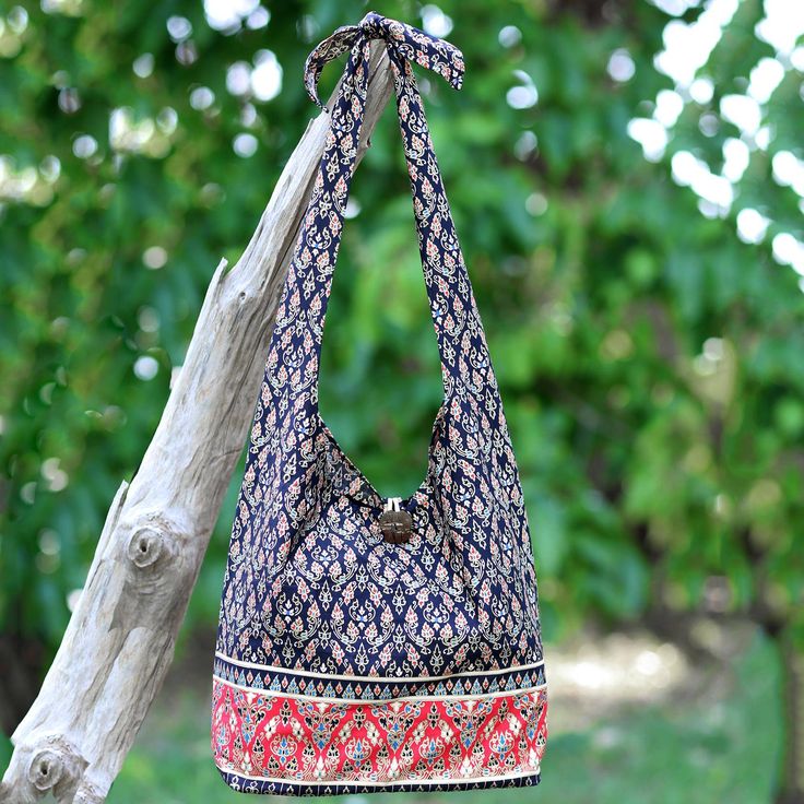 Thai artisan Jiap Rojjana designs this dramatic shoulder bag. Made from 100% cotton the bag features a traditional Thai design in black and red. Black cotton lining and a zip pocket are on the inside of the bag which closes with a coconut shell button. The strap can be conveniently adjusted by retying the knot at the desired length. Black Bohemian Cotton Bag, Black Cotton Rectangular Hobo Bag, Black Rectangular Cotton Hobo Bag, Red Bohemian Cotton Bags, Bohemian Red Cotton Bags, Red Bohemian Cotton Shoulder Bag, Red Cotton Shoulder Bag With Adjustable Strap, Elephant Bag, Thai Design