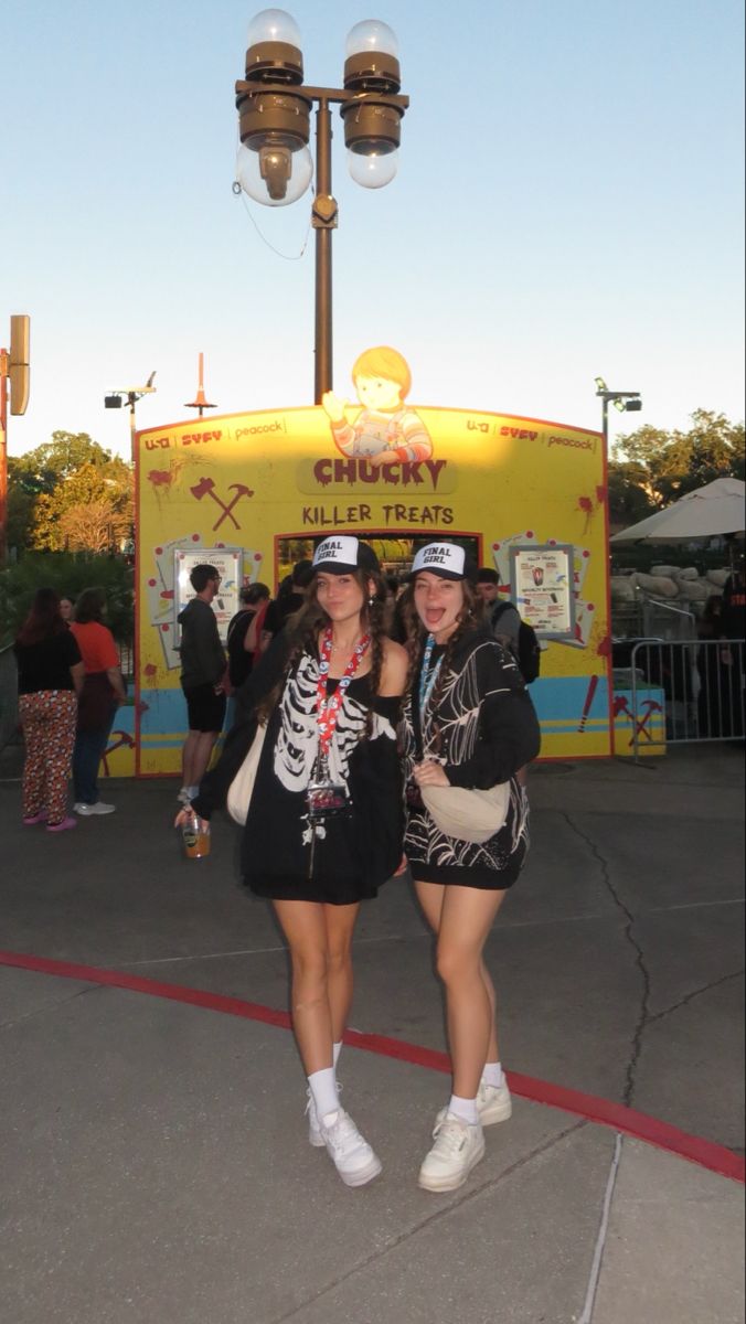 two women standing next to each other in front of a carnival booth