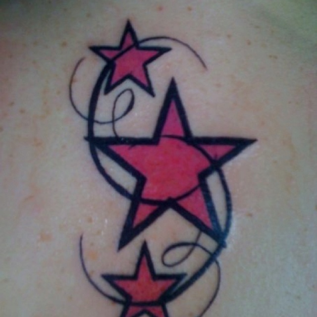 a star and crescent tattoo on the back of a woman's shoulder