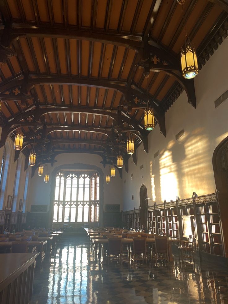 the inside of a large building with lots of windows and wooden ceiling beams on both sides