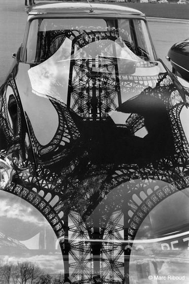 a car is shown with the eiffel tower reflected in it's rear window