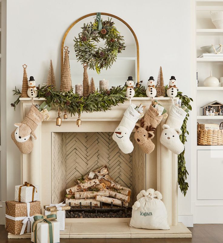 a fireplace decorated for christmas with stockings and snowmen