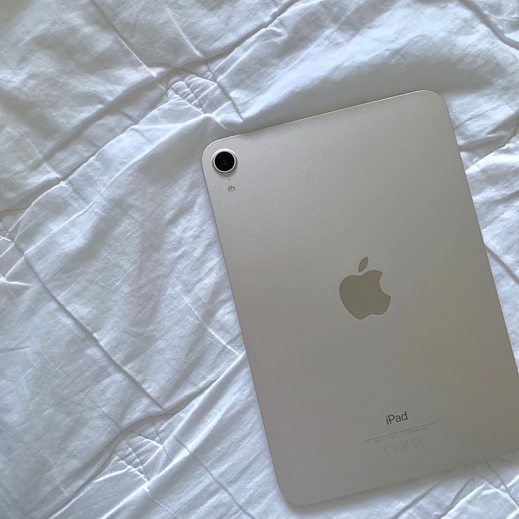 an apple ipad sitting on top of a white sheet